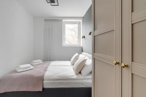 - une chambre blanche avec un lit et une fenêtre dans l'établissement Flatbook - City Center Apartments Kamienna Grobla, à Gdańsk