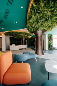 pokój z drzewem, kanapą i stołami w obiekcie R2 HIGOS BEACH w mieście Costa Calma