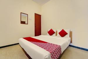 a bedroom with a large bed with red pillows at Hotel Trident Inn in Coimbatore