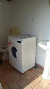 uma máquina de lavar roupa na casa de banho com WC em Casa Grande 