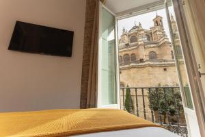 a bedroom with a window with a view of a church at Casa Miravalle Catedral in Granada