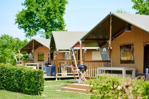 een rij stacaravans in een tuin bij Glamping Betuwestrand in Beesd