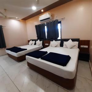 two beds in a hotel room with at Hotel Purushottam in Dwarka