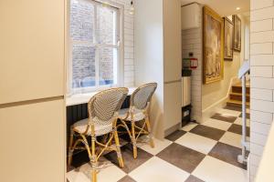 a kitchen with a table and chairs and a window at The Kensington Place - Stylish 1BDR Flat in London