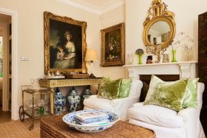 a living room with two white couches and a mirror at The Kensington Place - Stylish 1BDR Flat in London