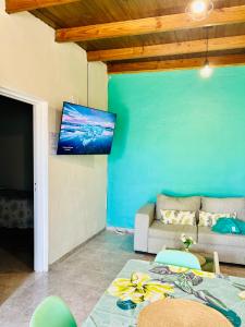 sala de estar con sofá y TV de pantalla plana en Casa Completa en Río Gallegos