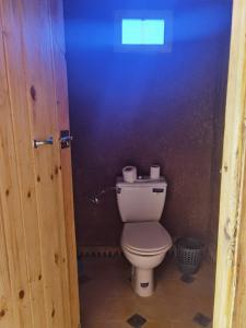 a bathroom with a toilet and a purple wall at Sun Bivouac Chegaga in El Gouera
