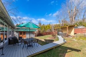 a wooden deck with a table and an umbrella at Candyland Cottage in Candler