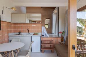 uma cozinha e área de refeições com uma mesa e uma sala de jantar em Villa Serena Eco-Lodges em Garopaba