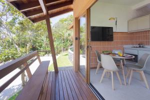 a wooden deck with a table and chairs on it at Villa Serena Eco-Lodges in Garopaba