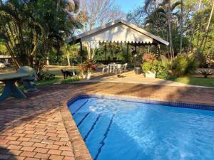 a swimming pool in a backyard with a gazebo at Tarentilos in Tzaneen