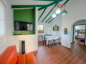 a living room with a table and a green wall at Hotel Barranqueros Soledén in Armenia