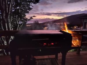 a grill with a fire in it at night at Casa de Ushuaia in Ushuaia +8 photos