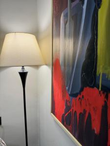 uma lâmpada sentada ao lado de um quadro na parede em Bejart Apartment 3 em Tirana