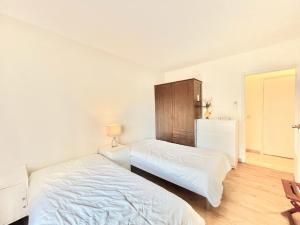 a bedroom with two beds and a cabinet at Arènes by Welcome to Cannes in Cannes