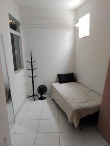 Una pequeña habitación con una cama y una ventana. en Casa família, en Cabo Frío