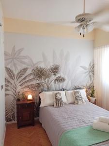 a bedroom with a bed with a tropical wallpaper at Exclusivo y luminoso Estudio c/Balcón in Buenos Aires +20 photos