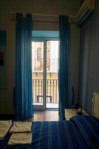 a bedroom with a bed and a window with a balcony at B&B Vivaldi in Palermo