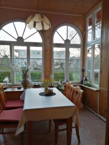 a dining room with a table and chairs and windows at Willa Wiselka in Wisełka