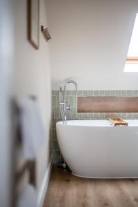 La salle de bains est pourvue d'une baignoire blanche et d'une fenêtre. dans l'établissement Castle Beach, à Broughty Ferry