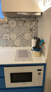 a kitchen with a white counter with a patterned wall at Le Conche Guest House - Casamassima in Casamassima