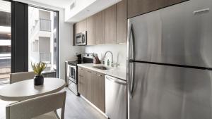 a kitchen with a stainless steel refrigerator and a table at The Bayfront in Miami