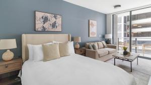 sypialnia z dużym białym łóżkiem i kanapą w obiekcie The Bayfront w Miami