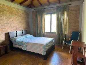 1 dormitorio con cama y pared de ladrillo en Casa Campestre Lago Calima, en Calima