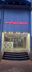 ein Gebäude mit einer Treppe vor einem Geschäft in der Unterkunft حكاية ليل للشقق الفندقية in Ha'il