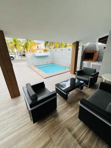 a living room with black furniture and a swimming pool at Casas Bote in El Morro de Barcelona