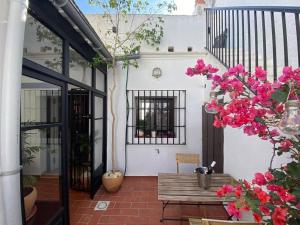 奇皮奧納的住宿－La Casa de Albahr，庭院设有木凳和粉红色的鲜花