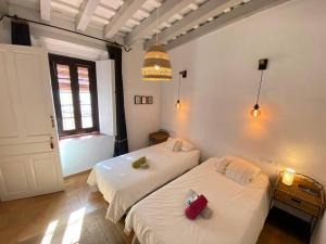 1 dormitorio con 2 camas y ventana en La Casa de Albahr en Chipiona
