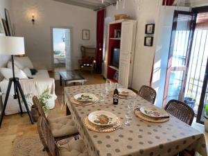 un comedor con una mesa con platos y copas de vino en La Casa de Albahr en Chipiona