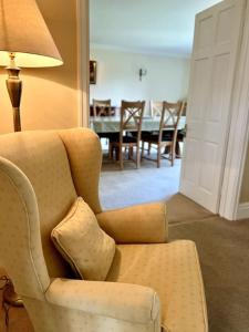un soggiorno con sedia e tavolo di Vast, Elegant Home with Indoor Pool & Sauna near Popular Golf Course a Kington