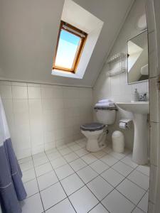 a bathroom with a toilet and a sink and a window at Cabaña El Mirador in Osorno
