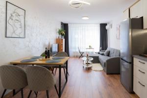 cocina y sala de estar con mesa y sillas en New Modern & Cozy apartment with FREE Private parking and EV charging station, en Varna