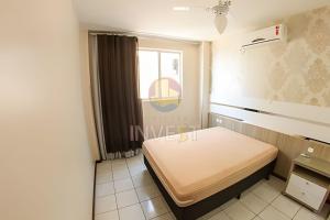 een slaapkamer met een bed in een kamer met een raam bij Lindo apartamento com vista mar frente a avenida in Bombinhas