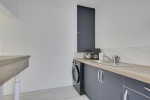 a kitchen with a sink and a washing machine at Chic studio near Paris in Colombes