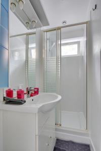 y baño blanco con lavabo y ducha. en Chic studio near Paris en Colombes