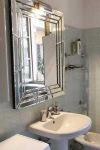 W łazience znajduje się umywalka i lustro. w obiekcie Appartamento Lagrange - Torino Centro w Turynie