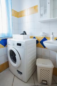 y baño con lavabo y lavadora. en Sardinia's house IUN R5500, en Gonnesa