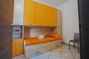 Dormitorio pequeño con litera y armarios amarillos en Sardinia's house IUN R5500, en Gonnesa