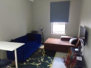 a living room with a blue couch and a bed at KellyCh Rosyka in Johannesburg