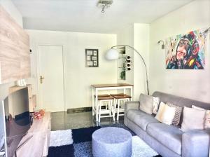uma sala de estar com um sofá e uma mesa em BEAULIEU-SUR-MER MAGNIFIQUE APPARTEMENT AVEC TERRASSE VUE Mer em Beaulieu-sur-Mer