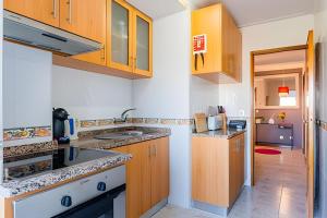 a kitchen with wooden cabinets and a sink at Stunning View Apartament by BnbHost in Vila Nova de Gaia