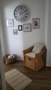 een kamer met een klok aan de muur en een stoel bij TKS-HOME in Mündersbach