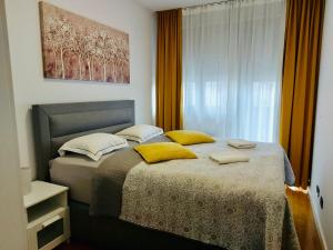 um quarto com uma cama grande e almofadas amarelas em Nova Galerija Studio Vita i Apartman Sara em Zagreb