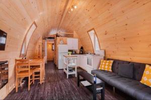 Cabaña de madera con sala de estar y cocina. en Chalet Éloise à louer avec spa Mauricie en Saint-Alexis-des-Monts