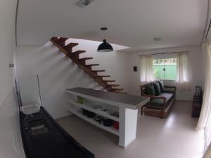 sala de estar con escalera y sofá en Vila Tiare Maresias, en Maresias