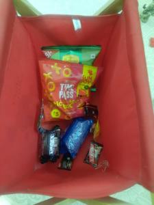 una caja roja llena de muchos dulces en shanthi home, en Puttaparti